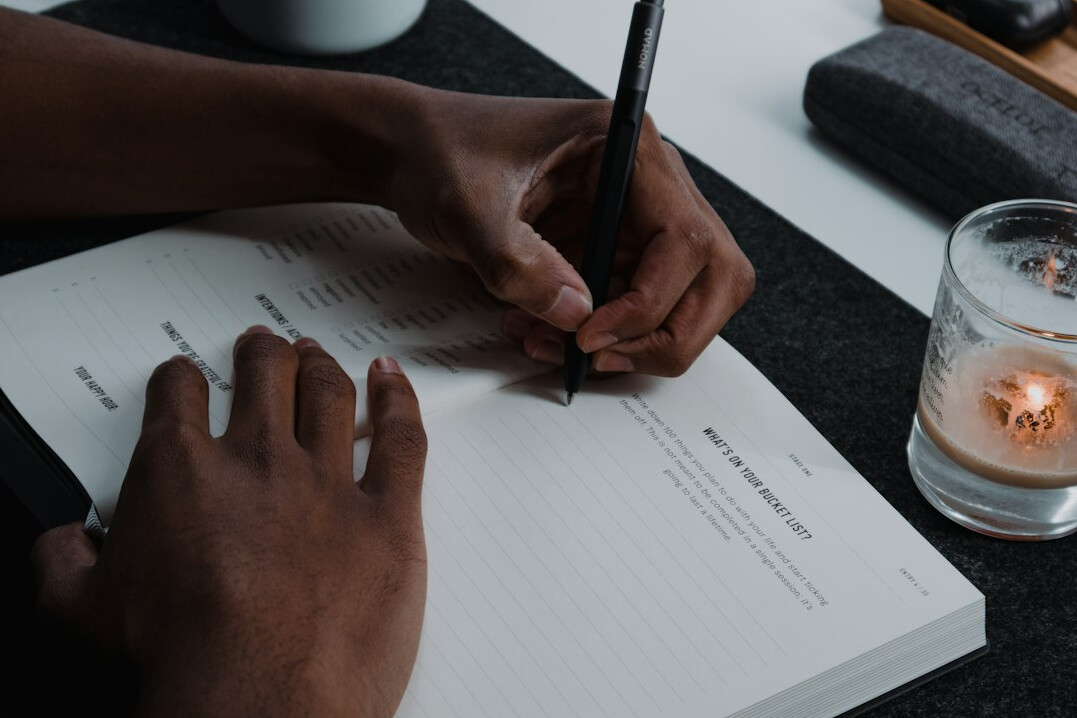 person writing in journal alone