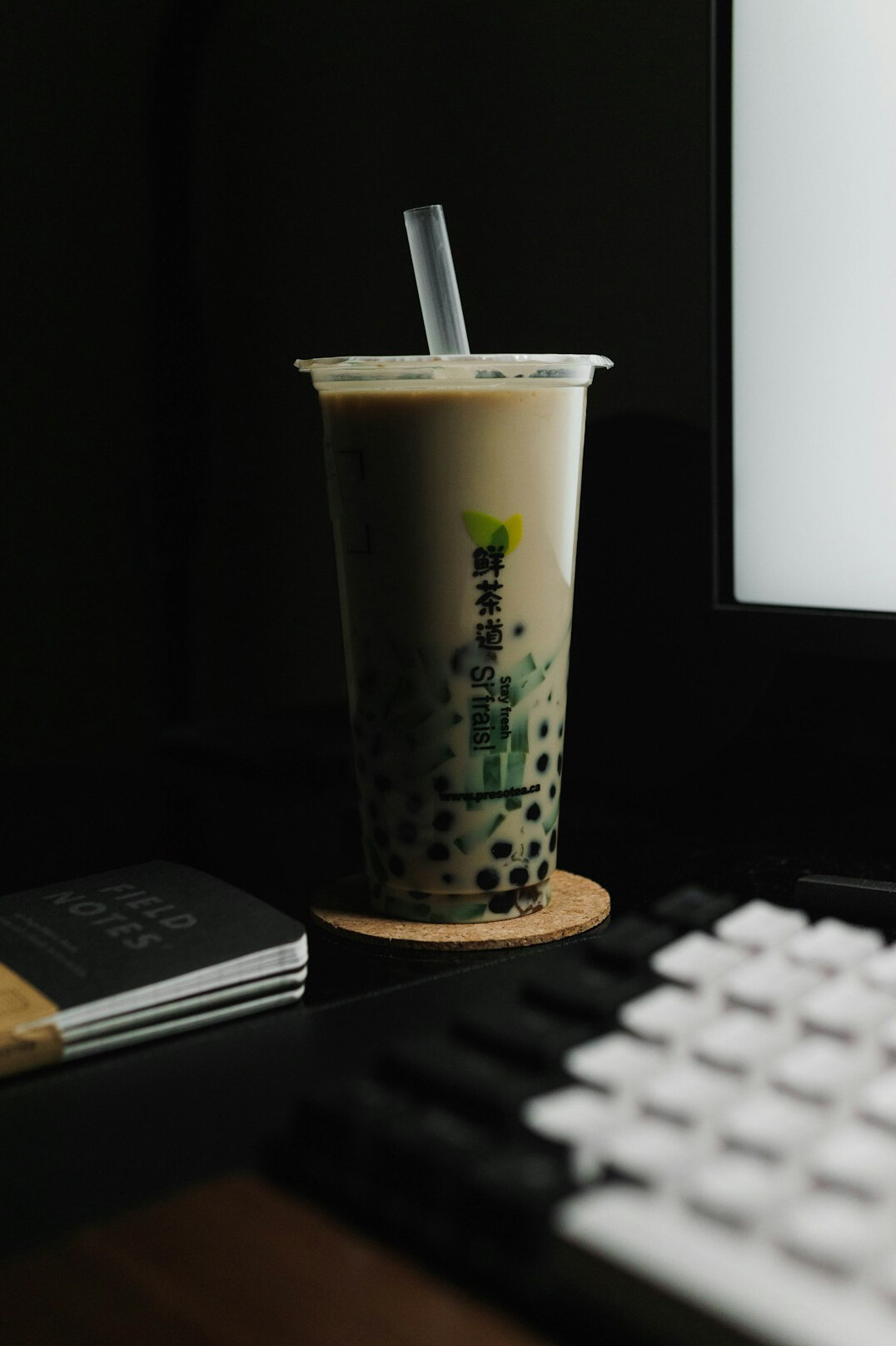 Flat lay of a notebook, pen and coffee cup on a wooden desk